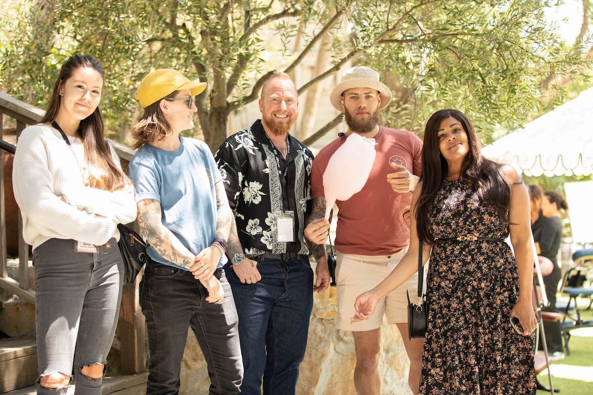 A group of people standing next to each other holding cotton candy.