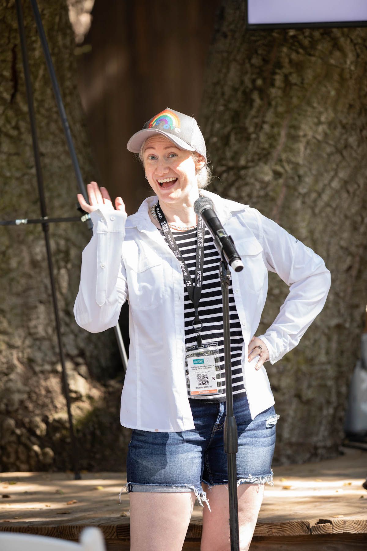 A woman is standing in front of a microphone and smiling.