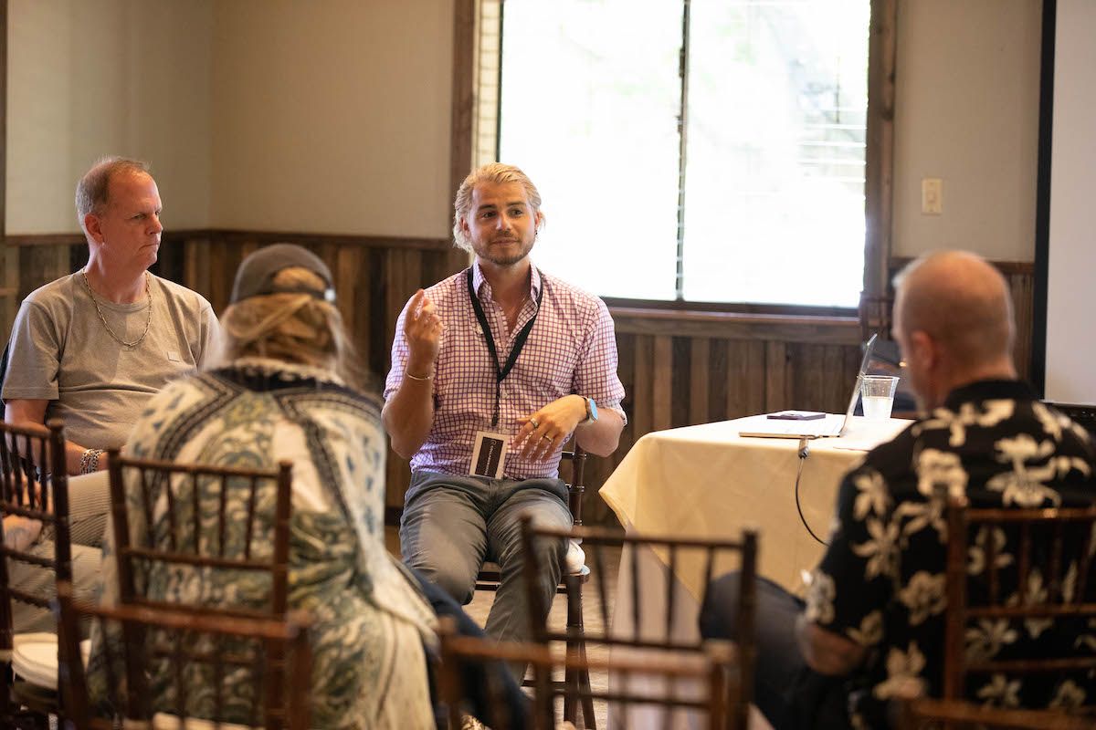 A group of people are sitting around a table in a room.