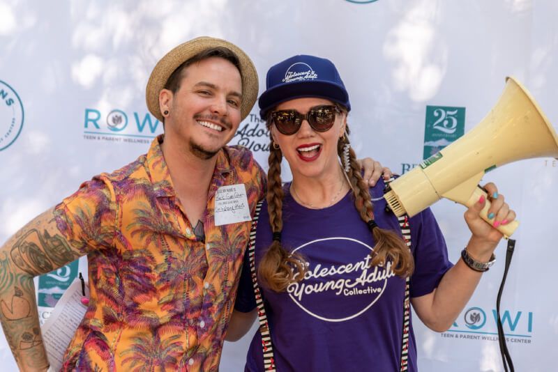 A man and a woman are posing for a picture while the woman is holding a megaphone.