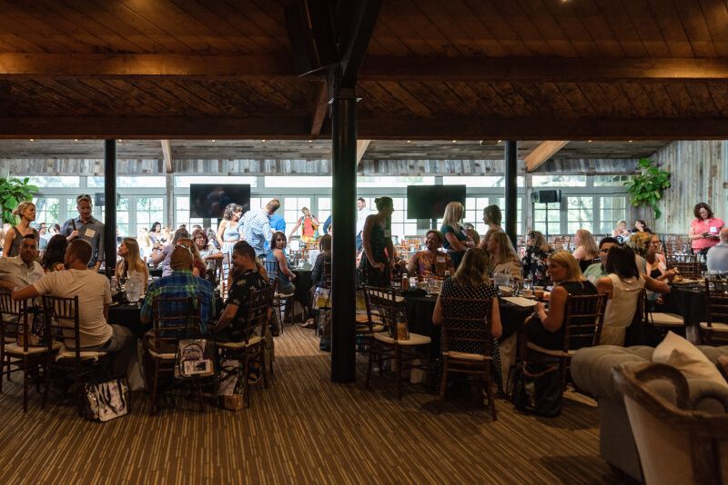A large group of people are sitting at tables in a restaurant.
