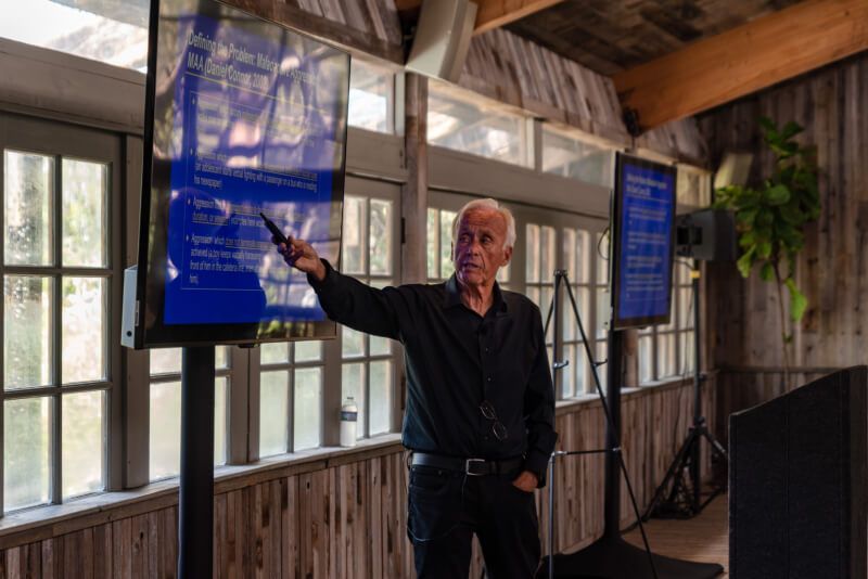 A man is giving a presentation in front of a large screen.