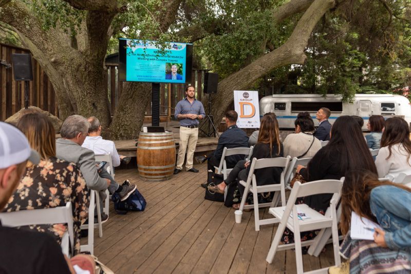 A man is giving a presentation to a group of people sitting in chairs.