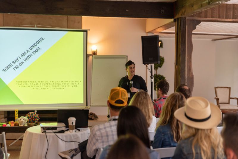 A group of people are sitting in front of a projector screen.