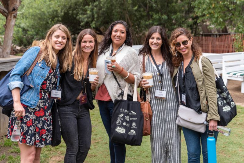 A group of women are posing for a picture in a park.