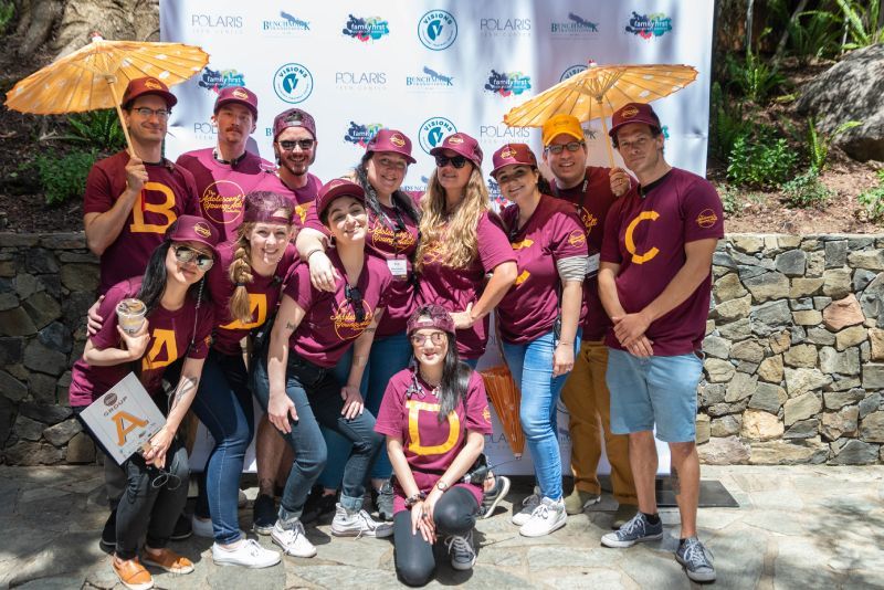 A group of people are posing for a picture in front of a wall.