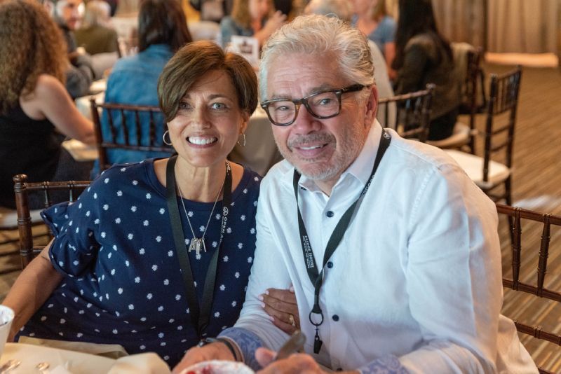 A man and a woman are posing for a picture at a table.