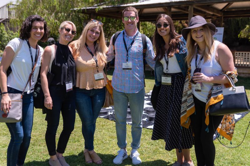 A group of people are posing for a picture in a park.