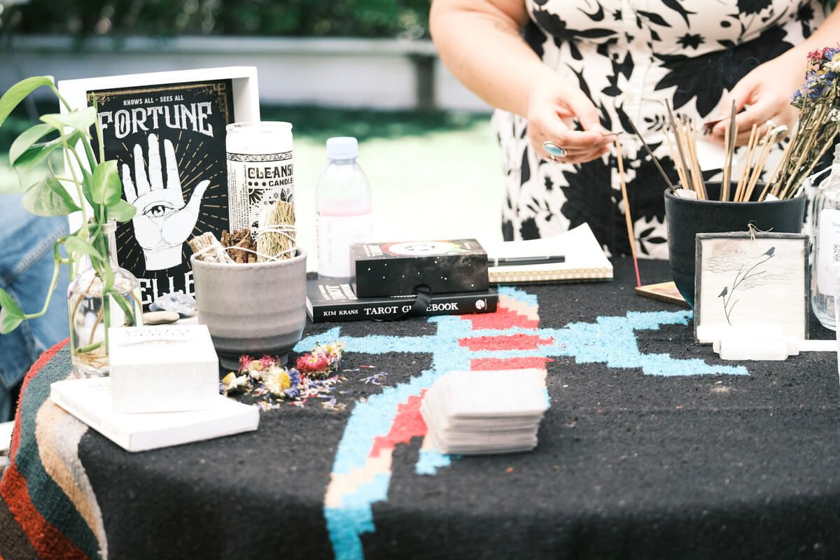 A woman is sitting at a table with a sign that says fortune on it.