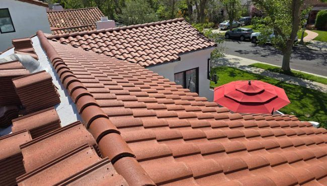 Red clay tile roof overlooking a suburban street, trees, and a red patio umbrella.
