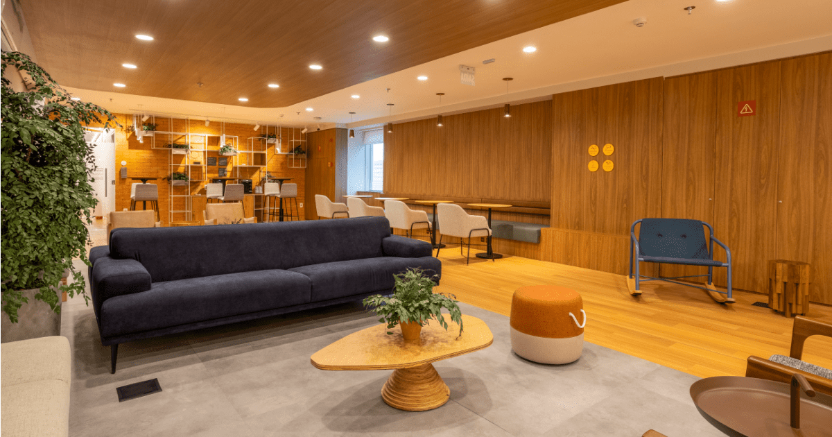 Uma sala de estar com um sofá azul e uma mesa de madeira.