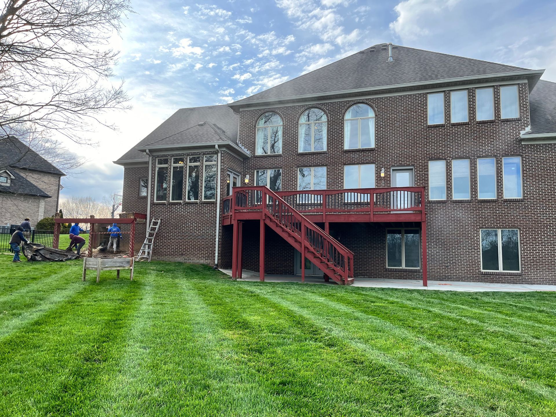 A large brick house with a large lawn in front of it.