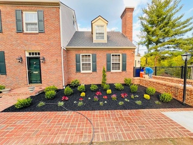 A brick house with a lush green lawn in front of it.