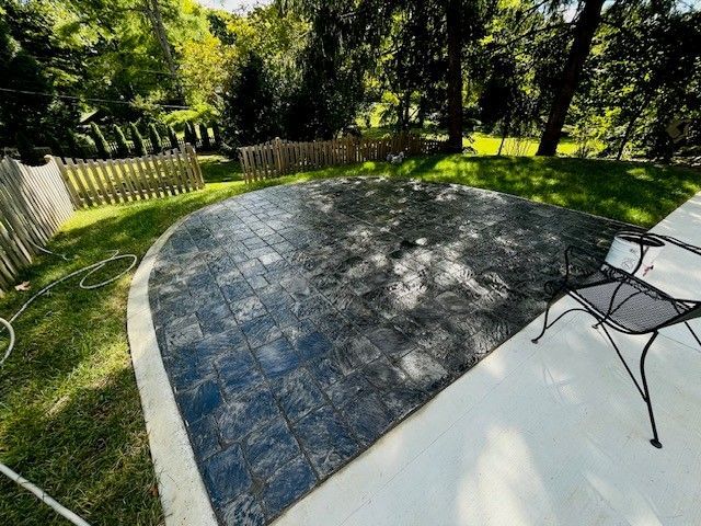 A patio with a chair and a table in the backyard.