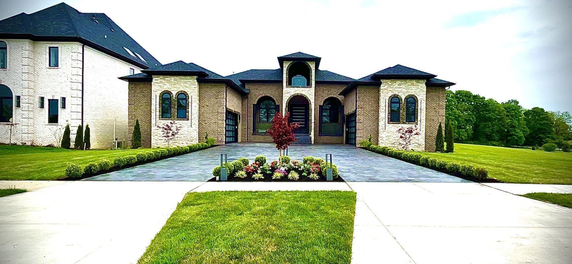 A large house is sitting on top of a lush green field.