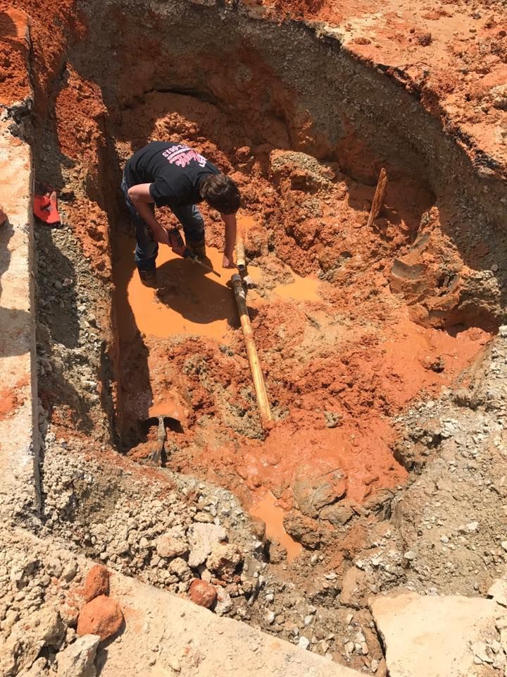 Worker Removing the Old Pipe in Backyard