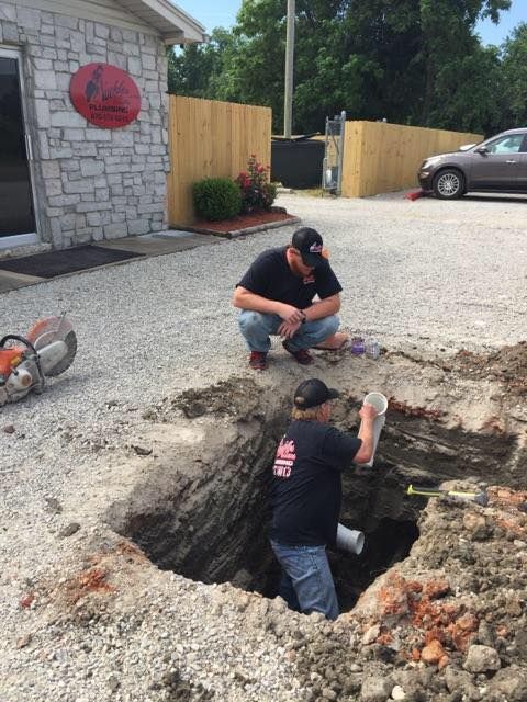 Two Men Digging in Backyard for Pipe Replacement