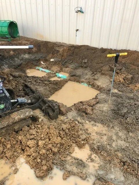 Muddy Excavation Site with Exposed Pipe
