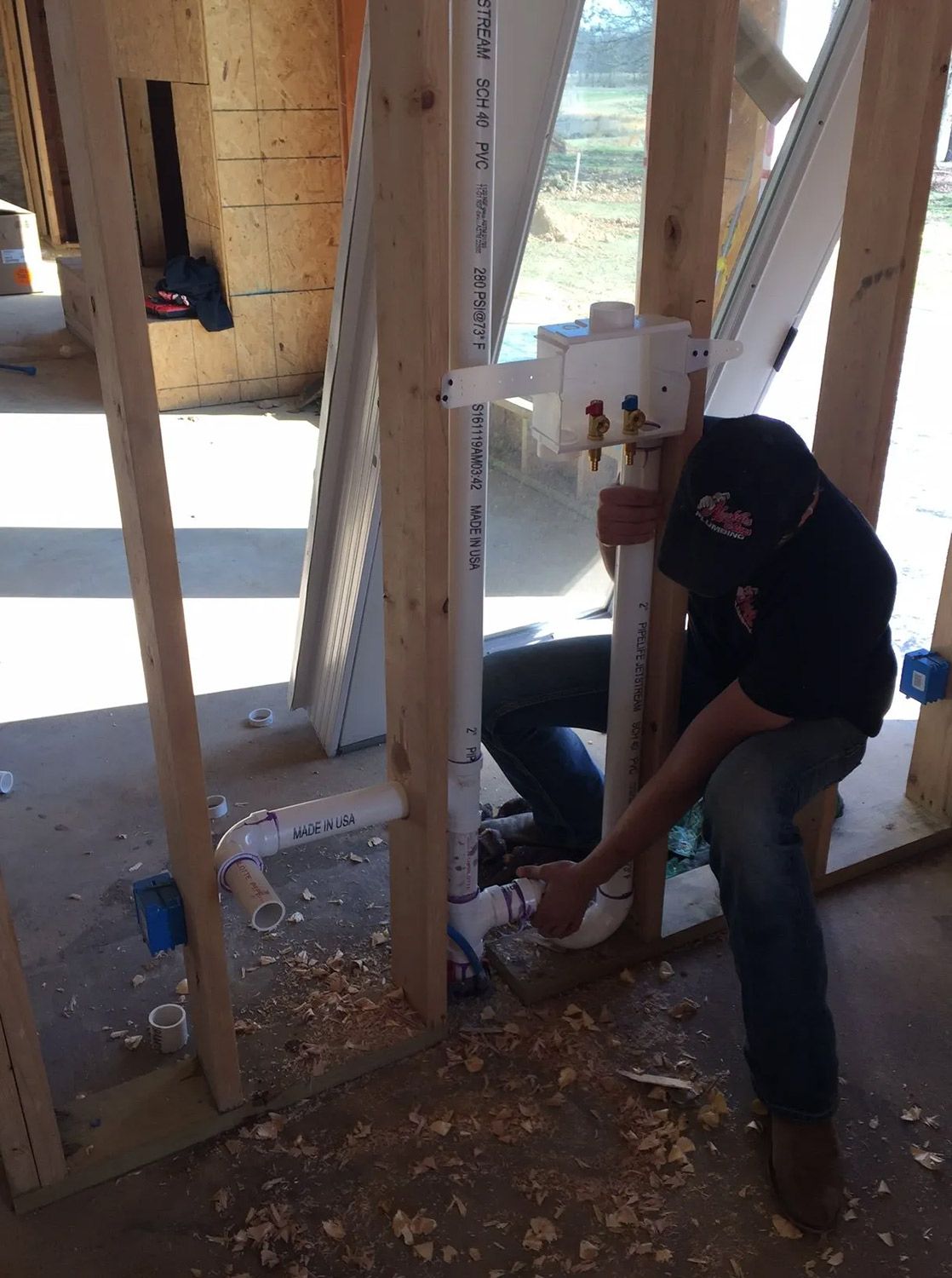 Plumber Installing PVC Pipes During Construction