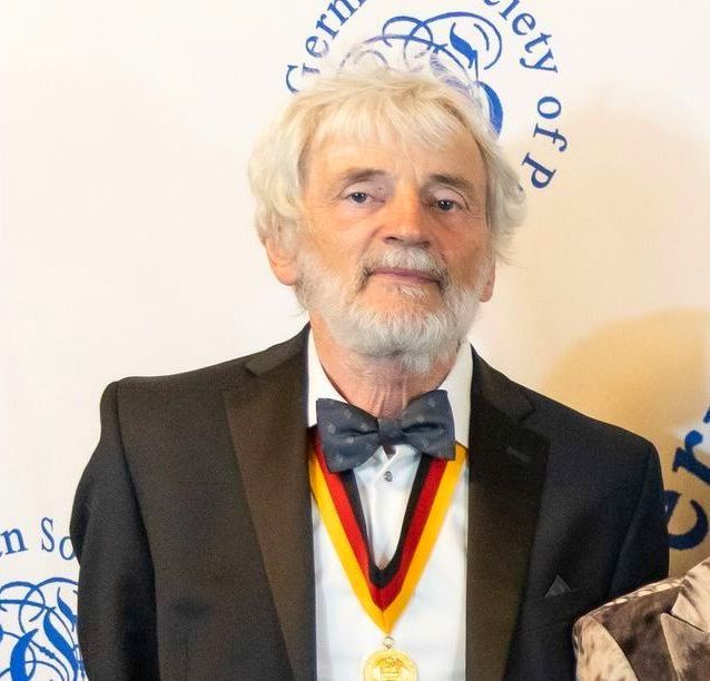 A man in a suit with a medal around his neck