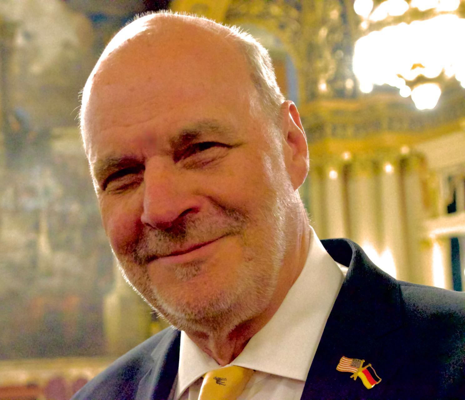 A bald man with a beard wearing a suit and tie