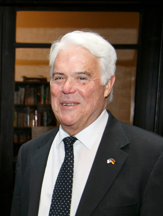 A man in a suit and tie is smiling for the camera