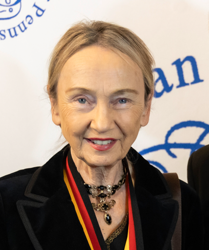 A woman wearing a black jacket and a medal around her neck
