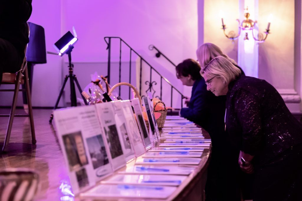 A group of people are sitting at a table looking at papers.