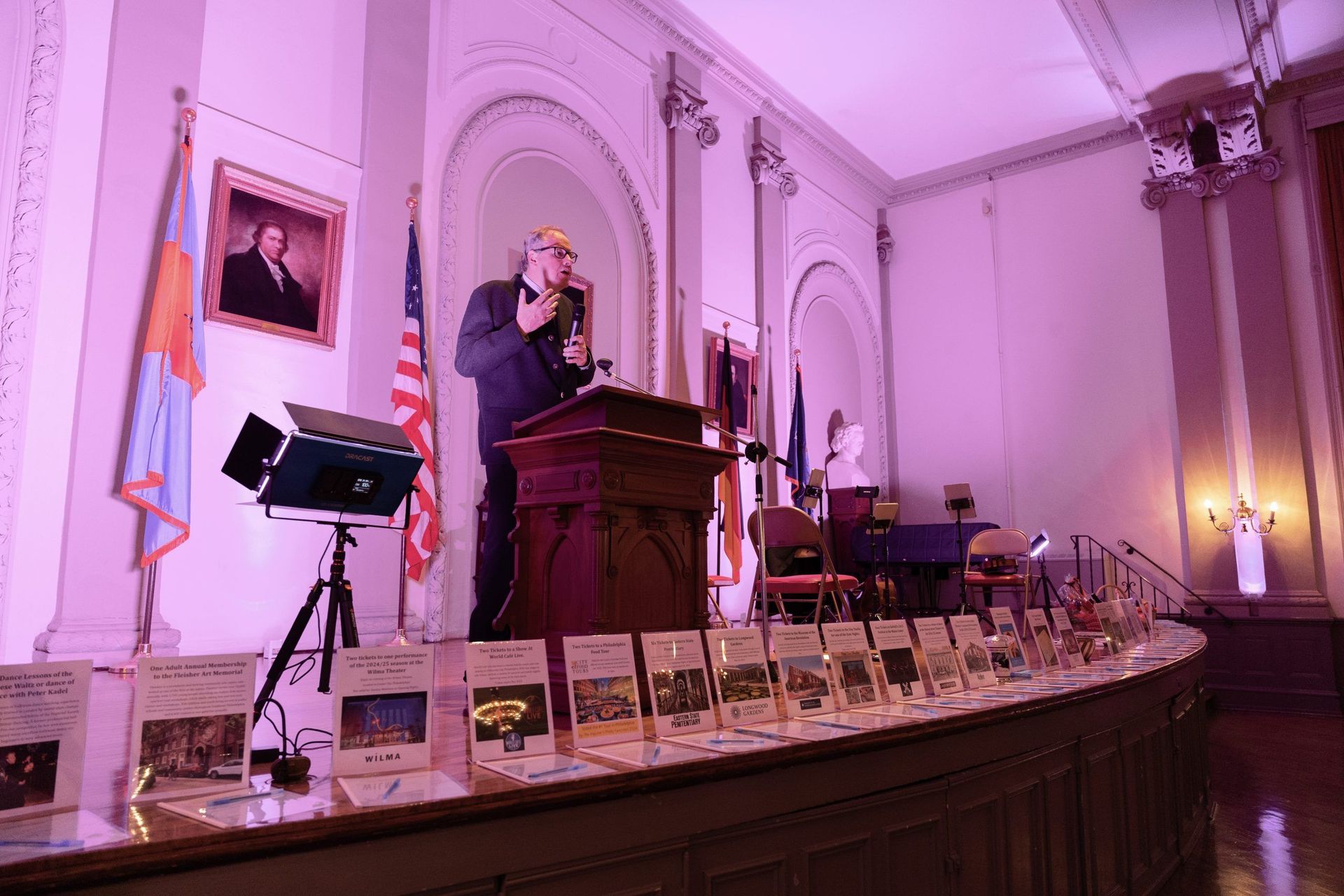 A man is standing at a podium giving a speech in a large room.