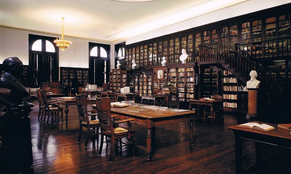 A library with lots of books and tables and chairs