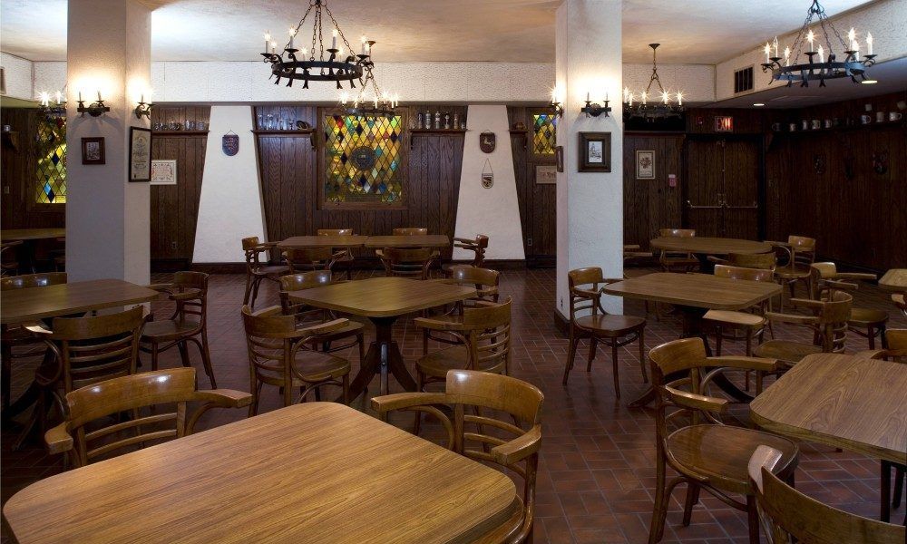 A restaurant with tables and chairs and a stained glass window