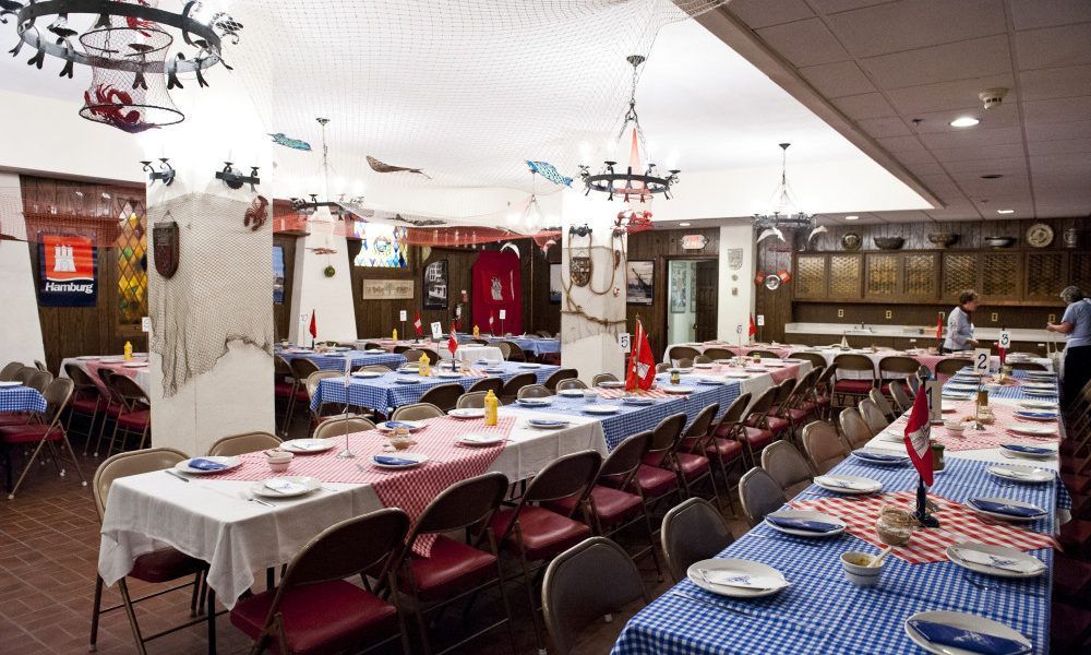A large room with tables and chairs set up for a party