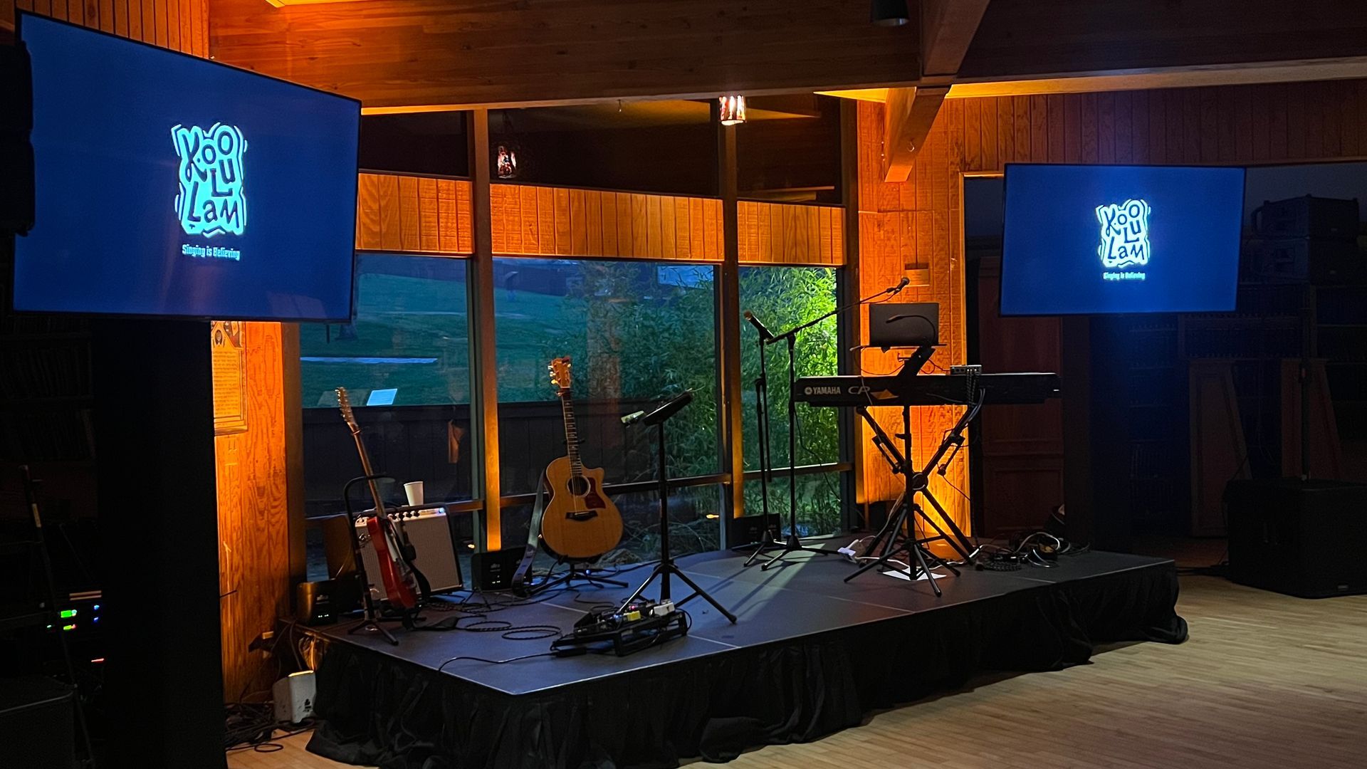 Stage set with instruments, screens, and warm lighting.