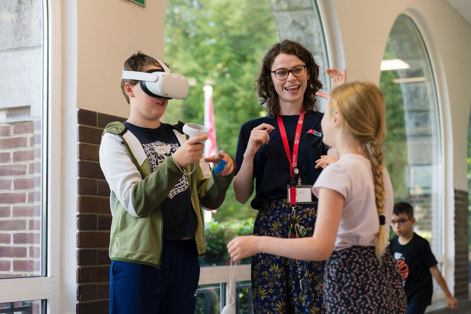 Je ziet een STEM-leerkracht die kinderen begeleidt bij een VR-game.
