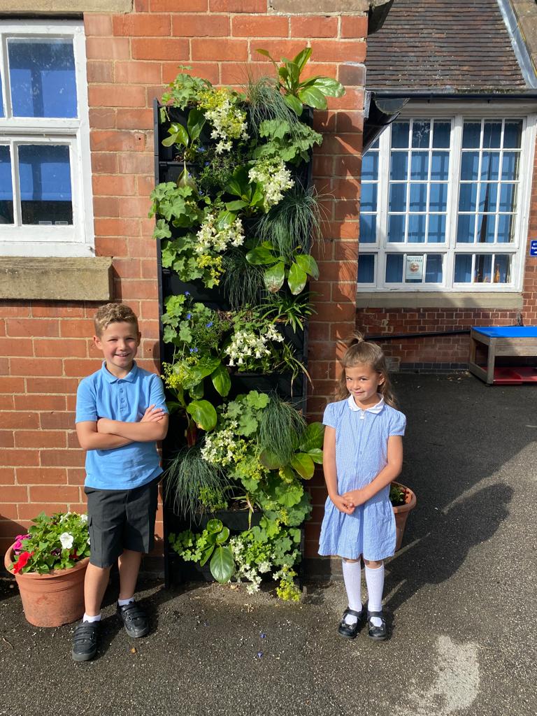 Picture of children standing by their schools recently installed plantbox living wall