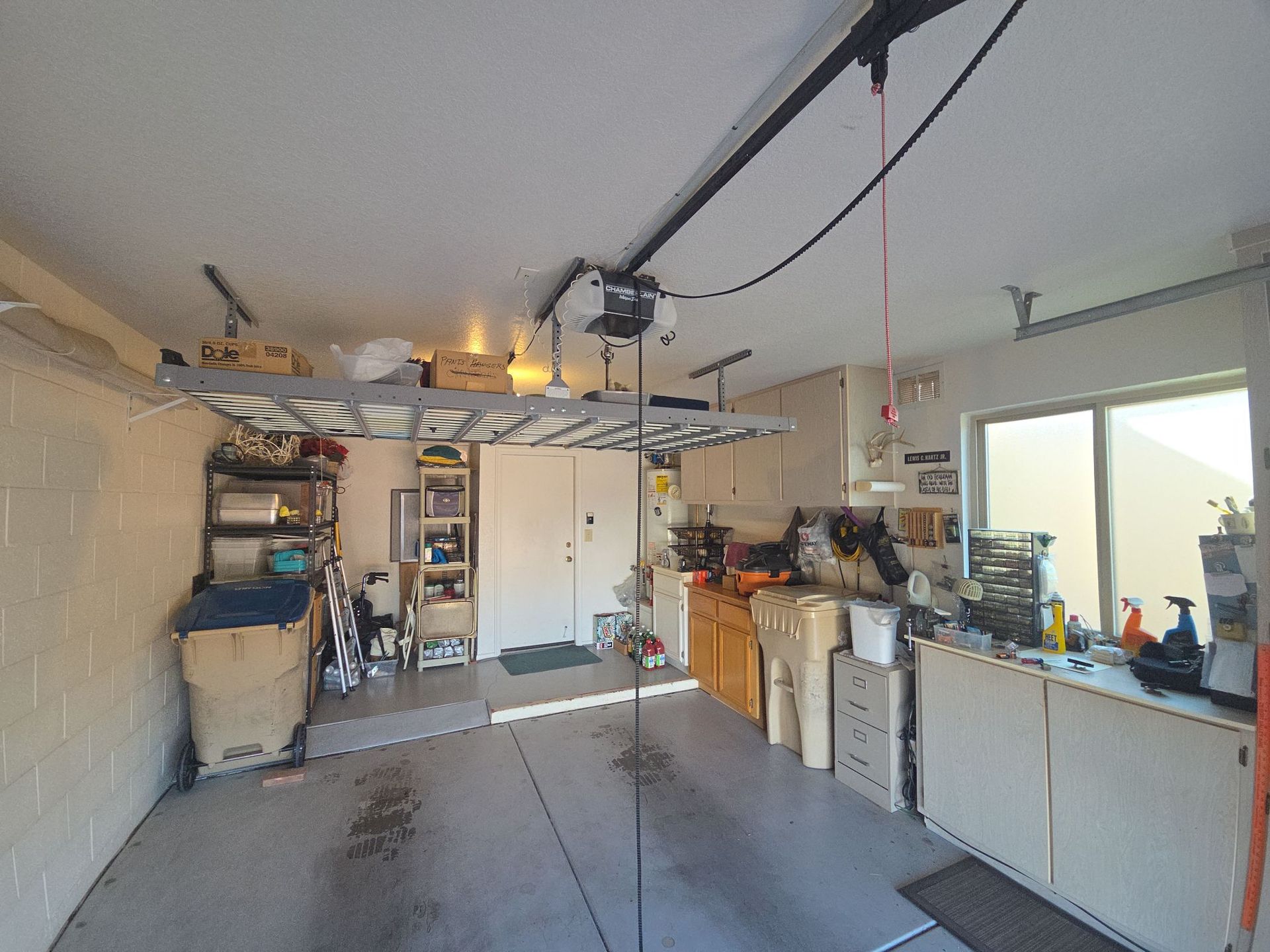 Gray garage door with window panels and stone accent.