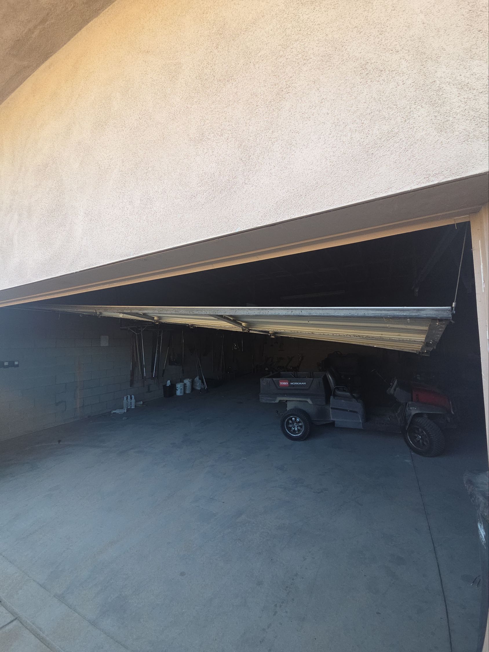 A man is using a drill to install a garage door.