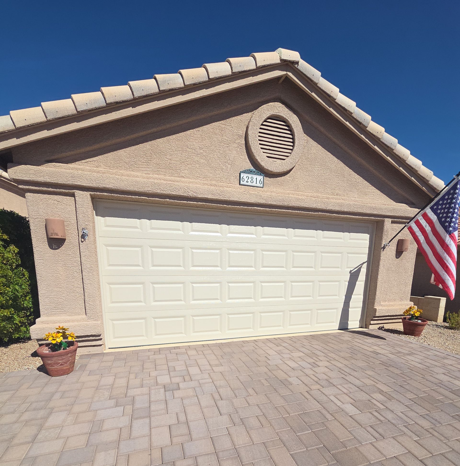 A white van is parked in a garage with a garage door open.