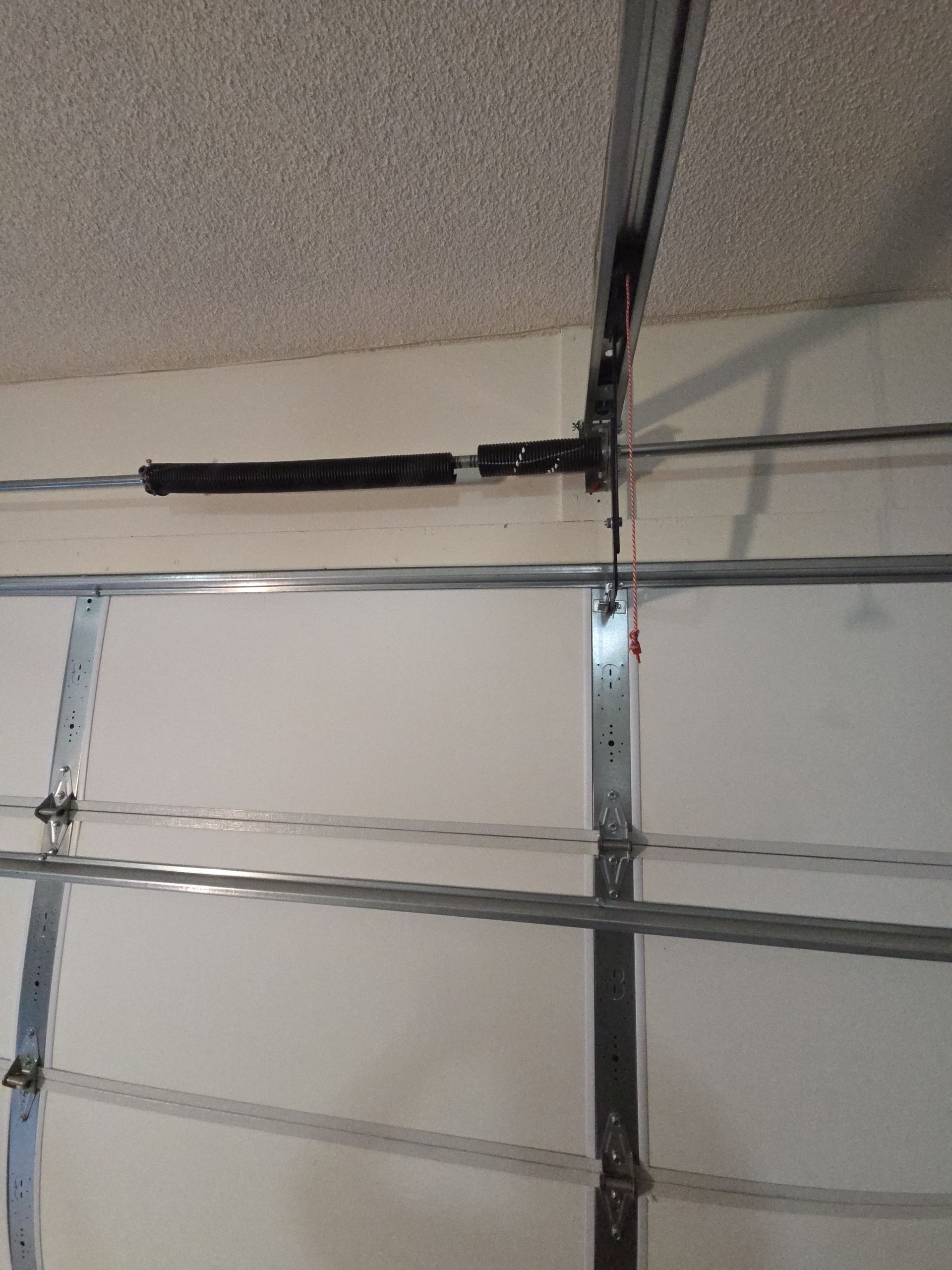 A white van is parked in a garage with a garage door open.