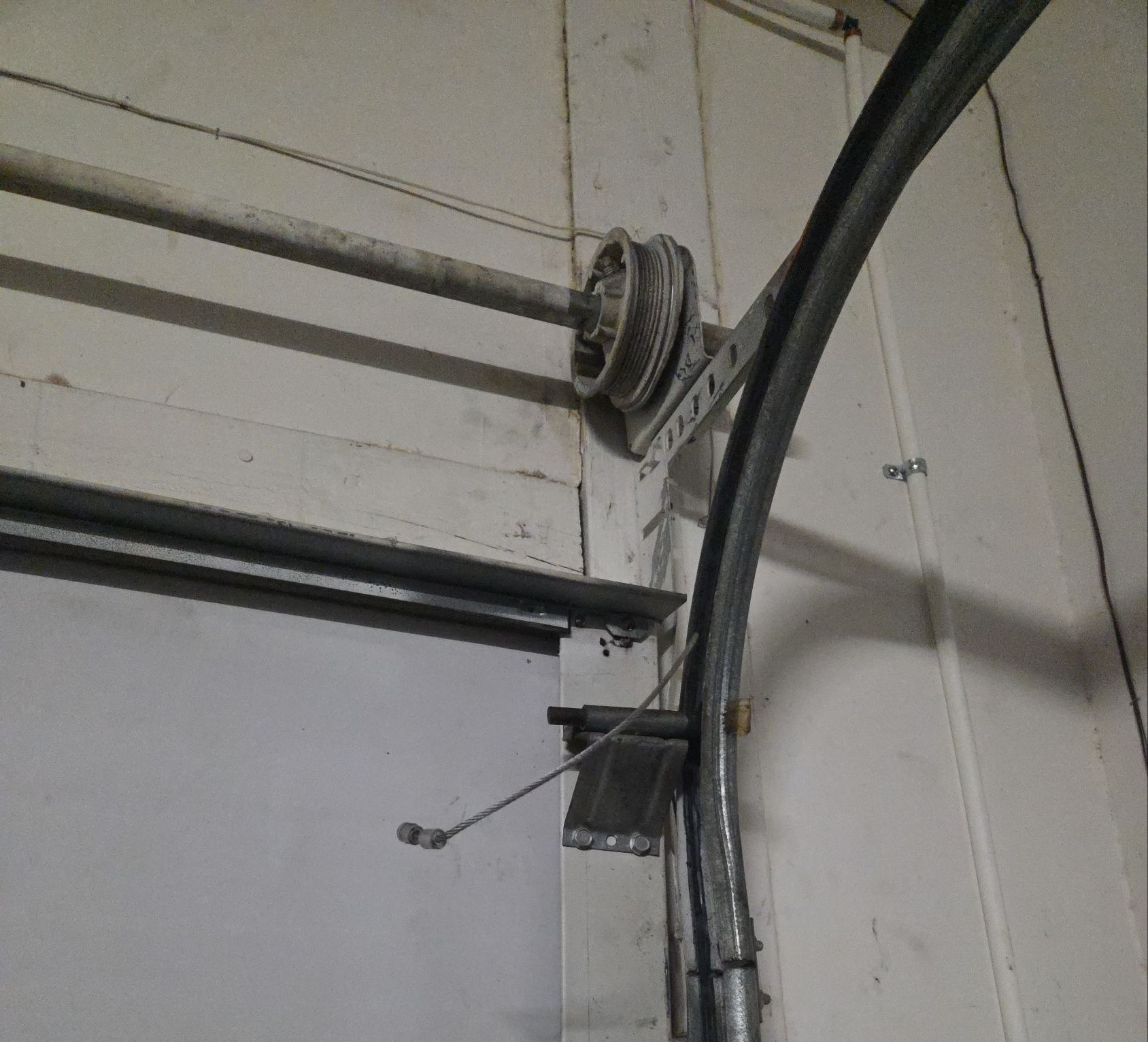 A white van is parked in a garage with a garage door open.