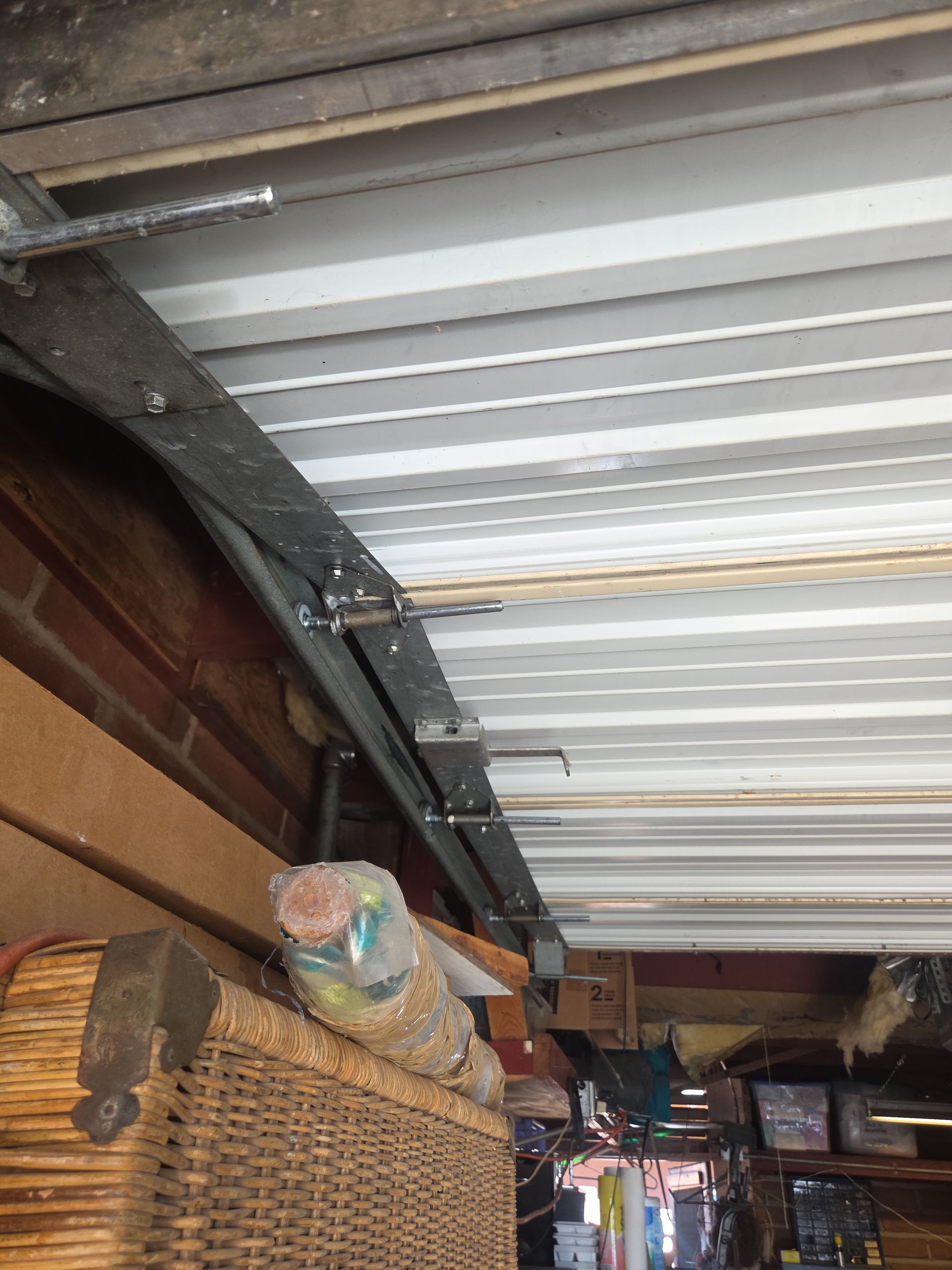 A white van is parked in a garage with a garage door open.