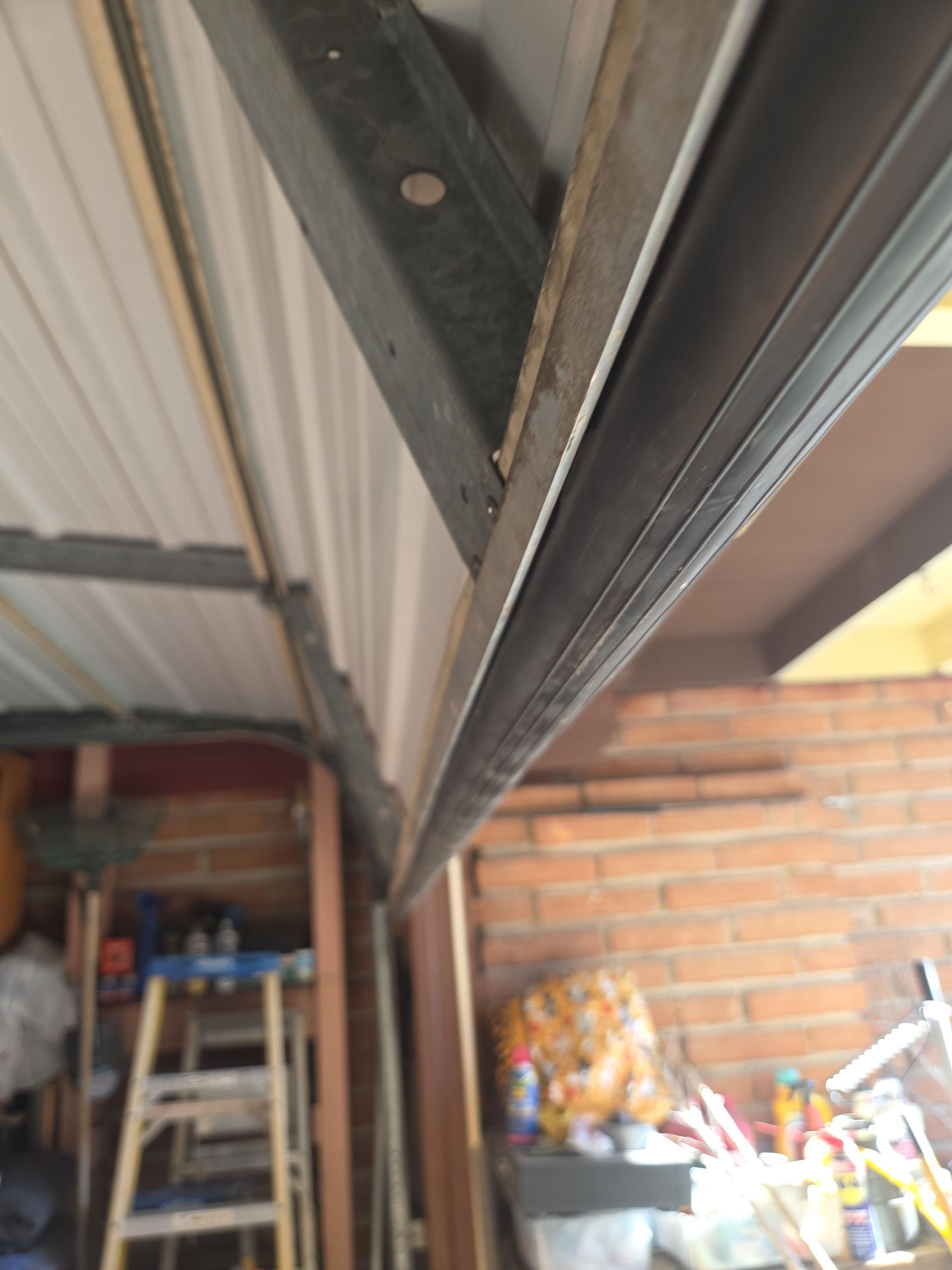 Gray garage door with window panels and stone accent.