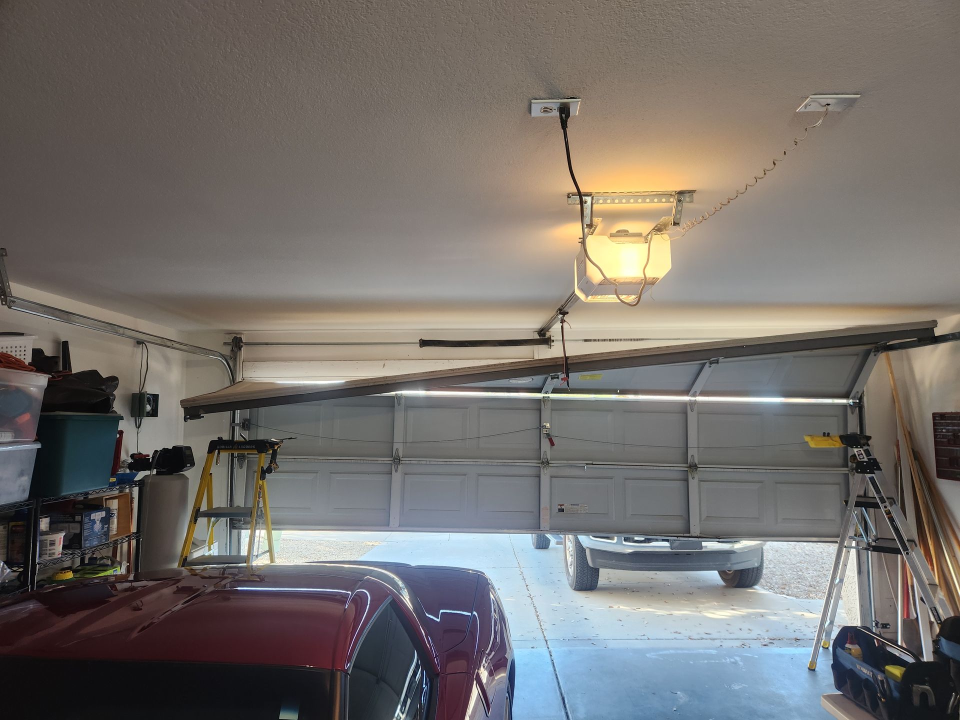 A white van is parked in a garage with a garage door open.