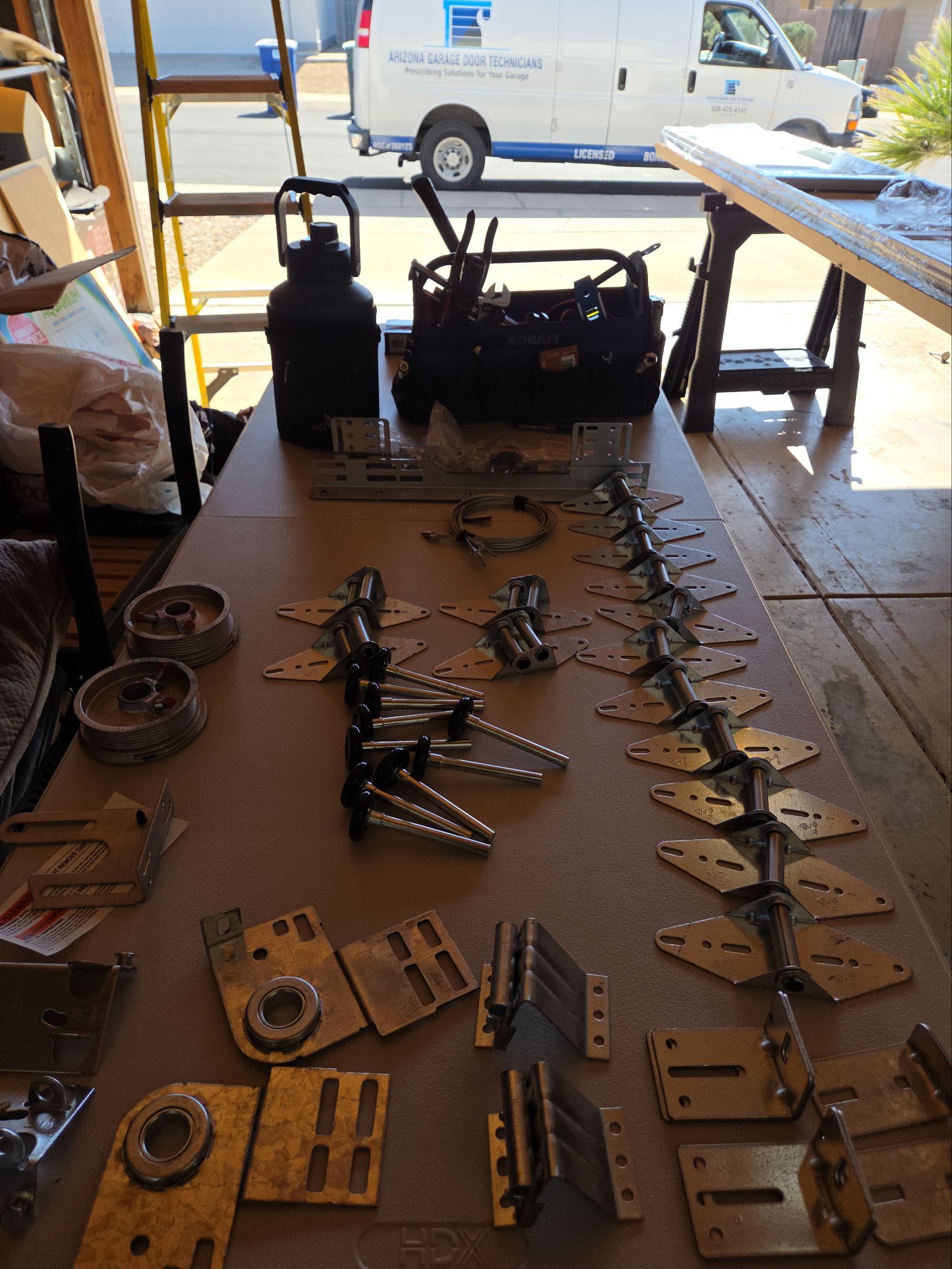 A white van is parked in a garage with a garage door open.