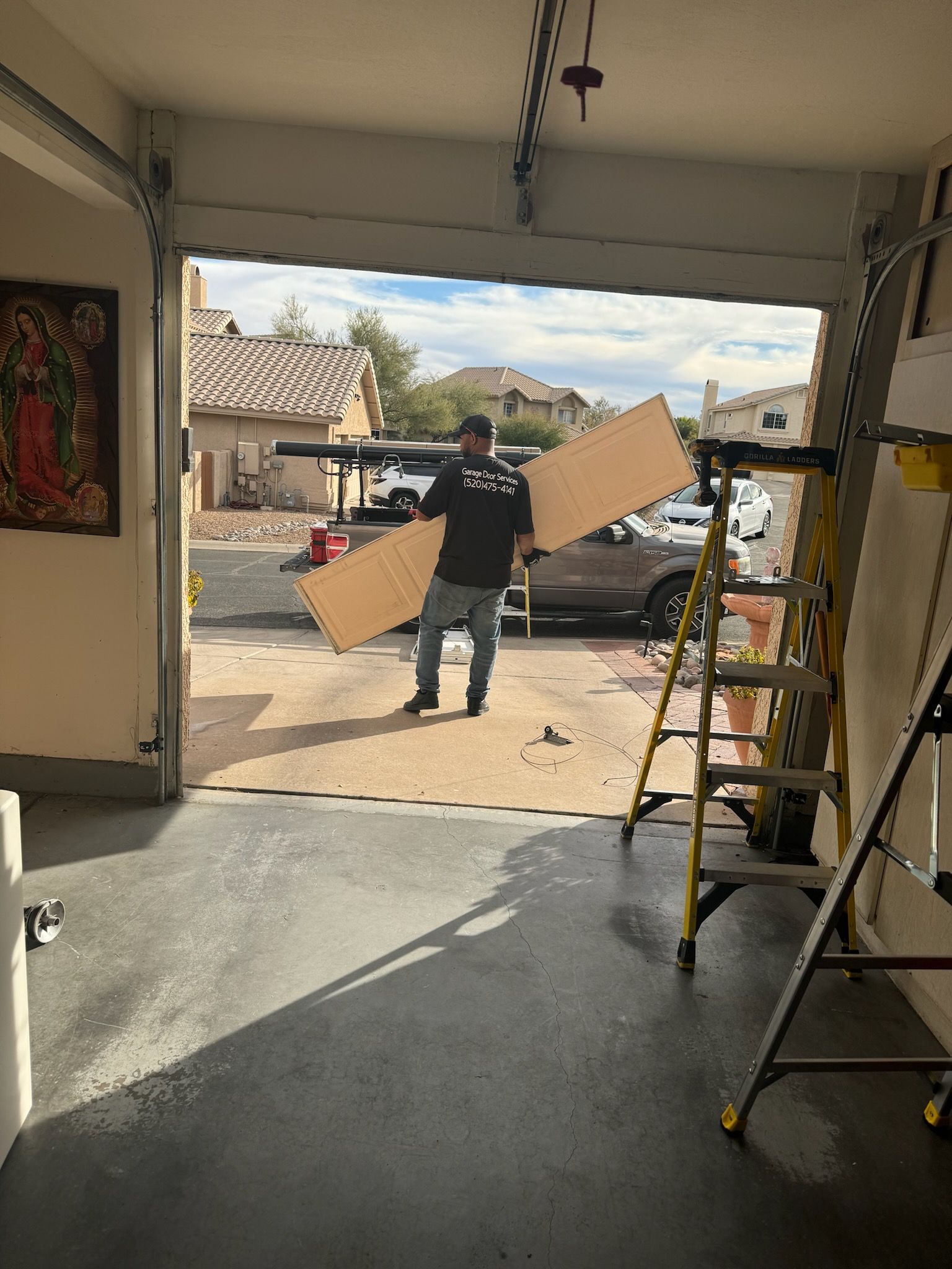Gray garage door with window panels and stone accent.