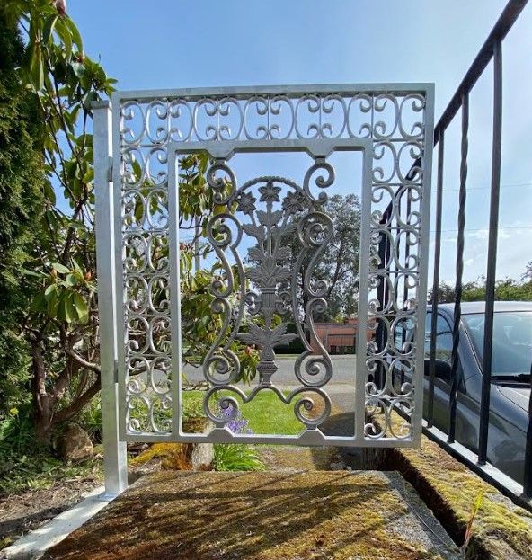 ornate white small pedestrian gate into a residential yard