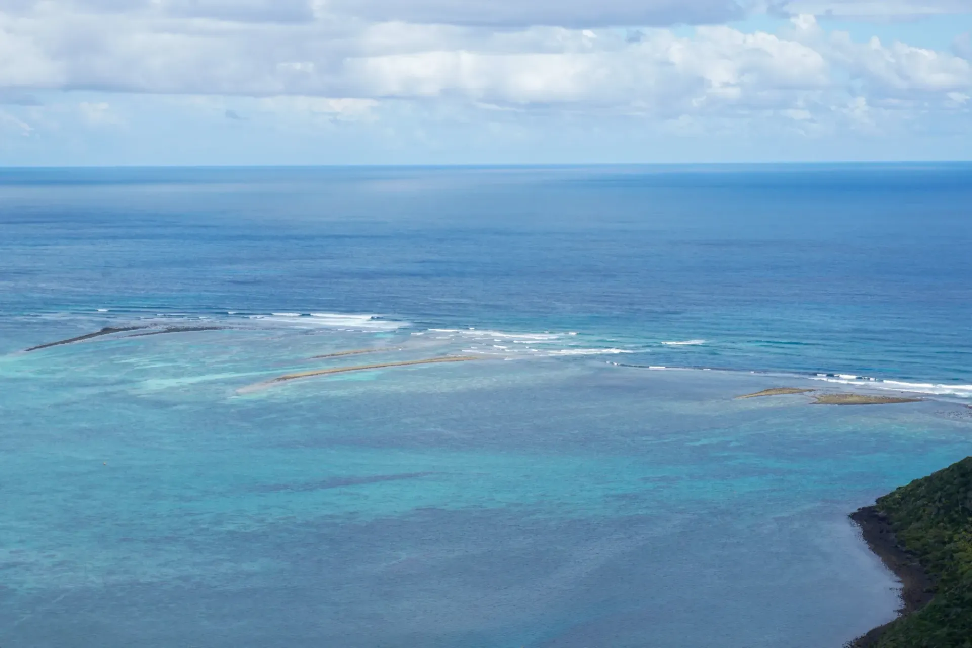 An aerial view of a large body of water with a cliff in the foreground.