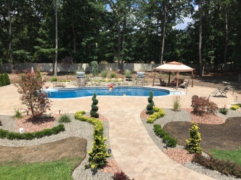A large backyard with a swimming pool and a gazebo