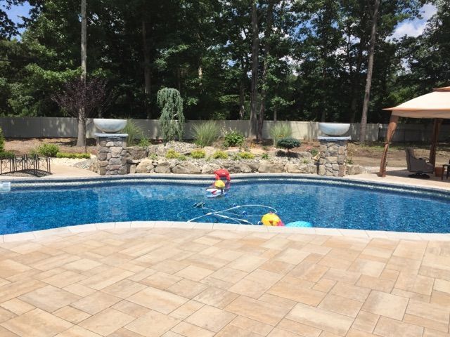 A large swimming pool with a gazebo in the background