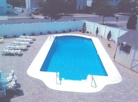 A large swimming pool with a white fence around it